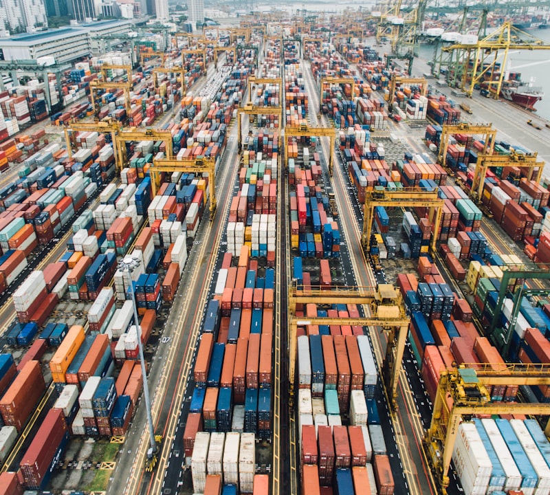 Container ship loading with cranes and forklift at port